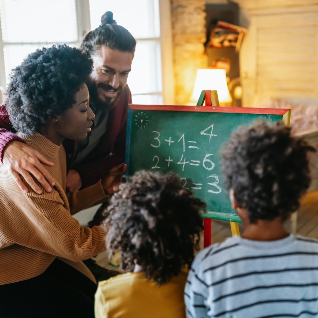 Happy children learning maths with multiethnic parents at home. Family education happiness concept